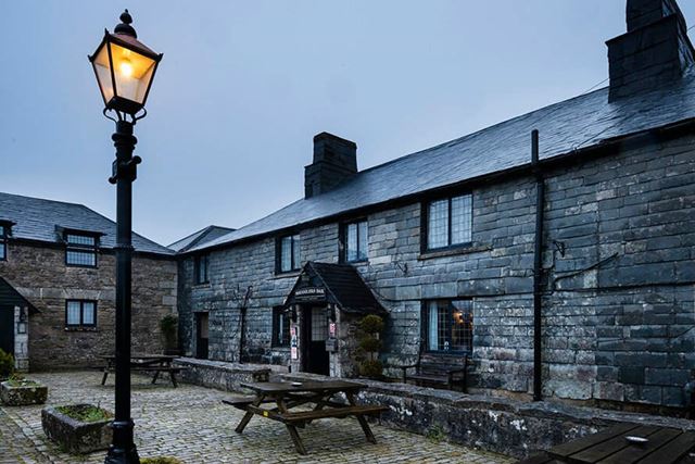 Brick and slate holiday home with a lit lamppost outside